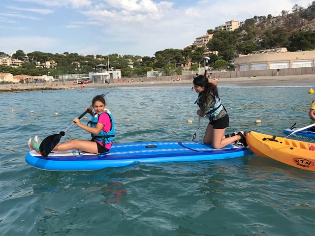 Deux jeunes filles apprenant à faire du canoe kayak en colonie de vacances