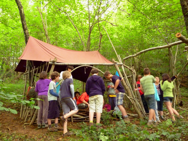 Groupe d'enfants construisant une cabane en colonie de vacances d'été