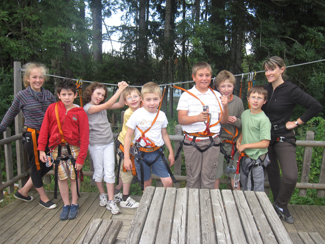 Groupe de jeunes enfants équipés pour faire de l'accrobranche en colonie de vacances