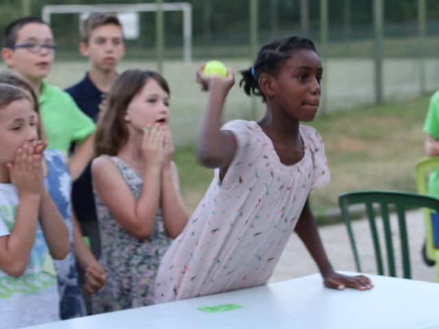 Jeune fille visant avec une balle en colonie de vacances d'été à la montagne