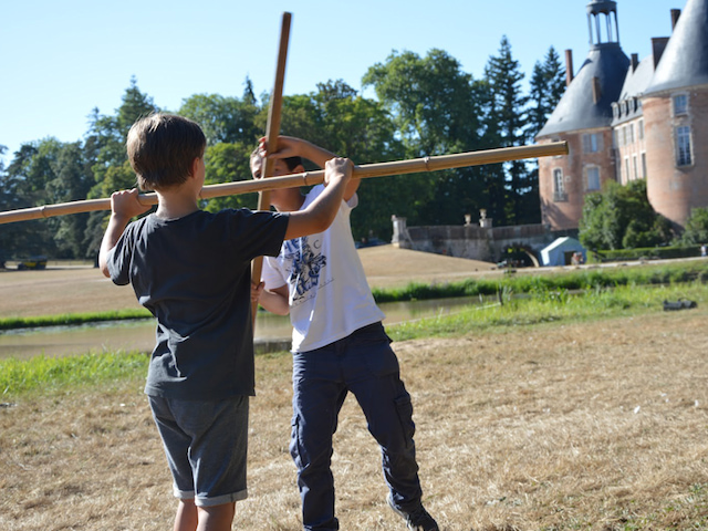 Enfants faisant une bataille de batons en colo médiévale 