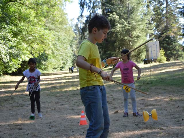 enfants s'entrainant à faire du diabolo en colonie de vacances 