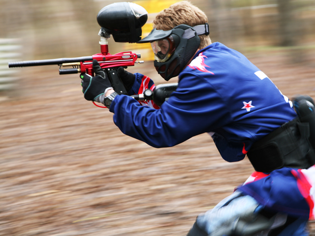 Adolescent jouant au paintball en colonie de vacances
