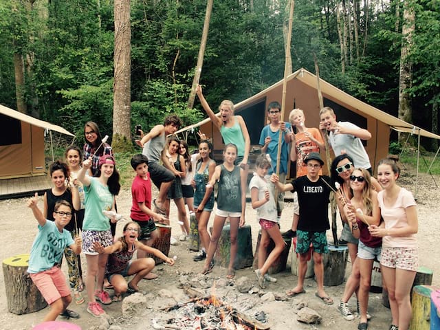 Groupe d'enfants autour d'un feu de camp en colonie de vacances cet été