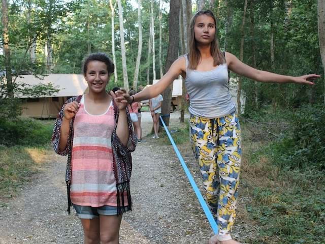 Deux jeunes filles faisant du slackline en colo d'été