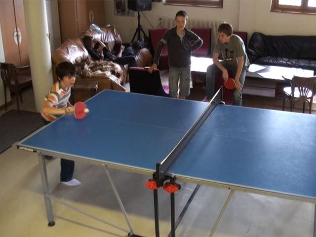 Enfants jouant au ping pong en colo