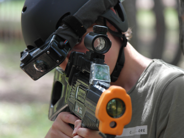 Portrait d'un enfant jouant au laser game extérieur en colonie de vacances