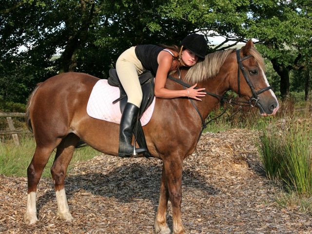 Adolescente avec son cheval en colo été