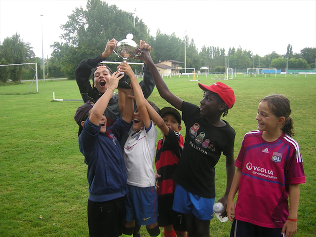 enfants tenant une médaille de foot en colonie de vacances cet été