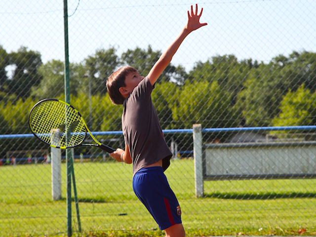 Enfant pratiquant le badminton en colo cet été 