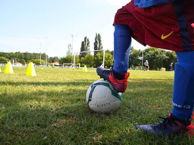 enfant en tenue de football en colonie de vacances sportive 
