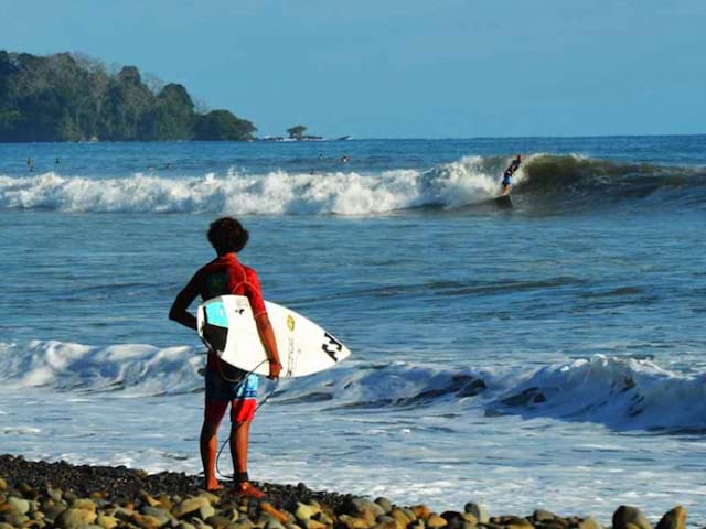 Adolescent avec sa planche de surf au Costa rica en colo