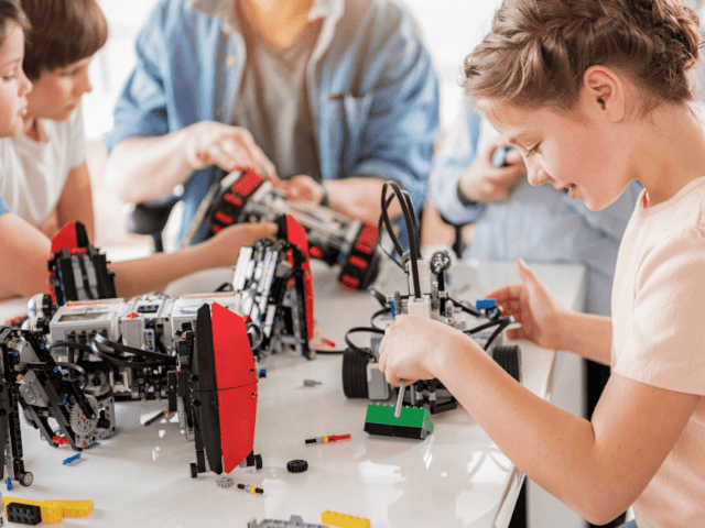 Groupe de jeunes qui s'amusent à des jeux de constructions en colo de vacances cet automne