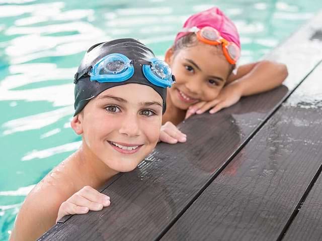 Deux jeunes enfants qui s'amusent en colo durant leur activité piscine dans les Pyrénées 