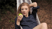 Gif d'une jeune fille mangeant une pomme sur un transat