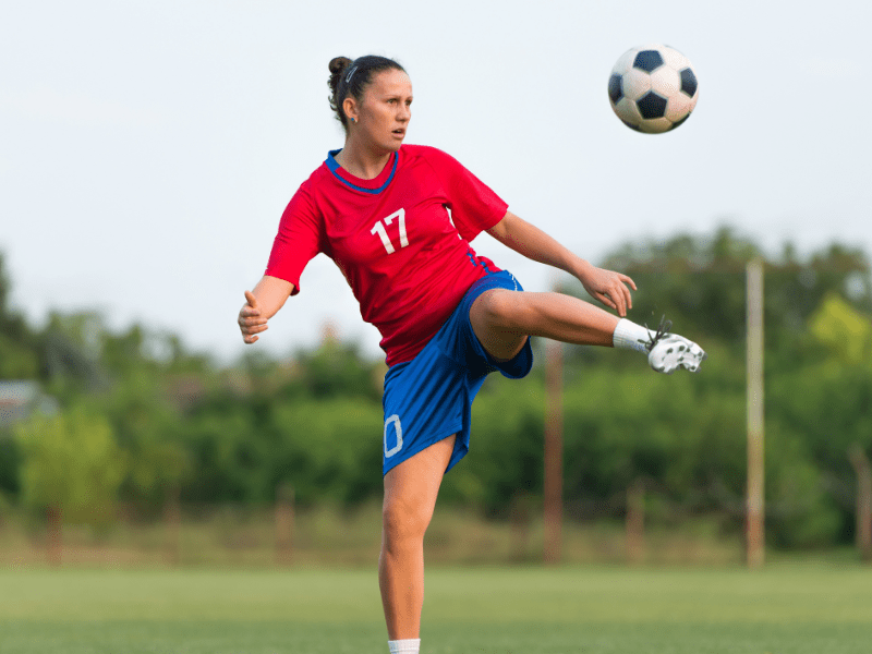 Vue sur une jeune fille qui joue au foot lors de sa colo multi activités de l'automne