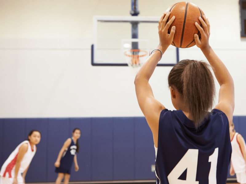 Jeune ado qui pratique le basket en colonie de vacances durant l'automne