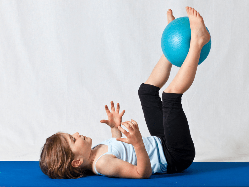 Jeune garçon qui s'amuse avec une balle en colonie de vacances cet hiver