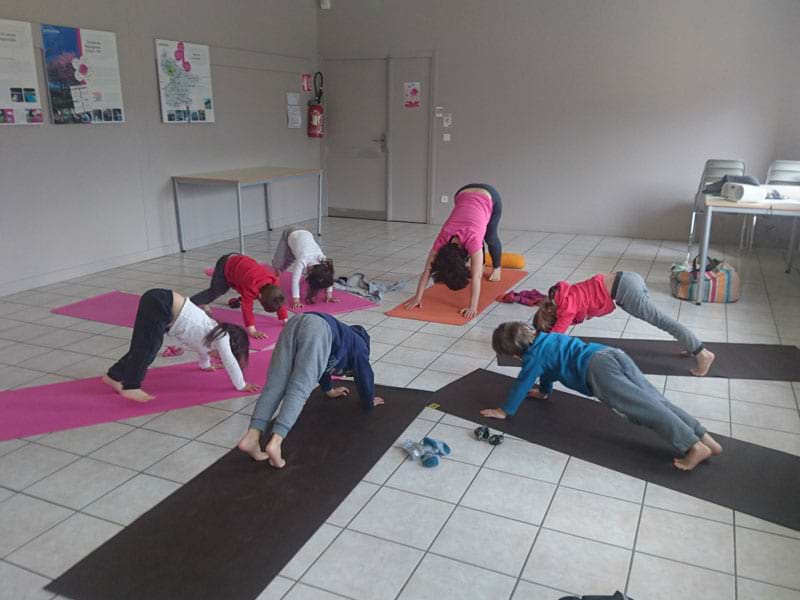 Groupe de jeunes enfants qui font des exercices d'étirement en colo de vacances