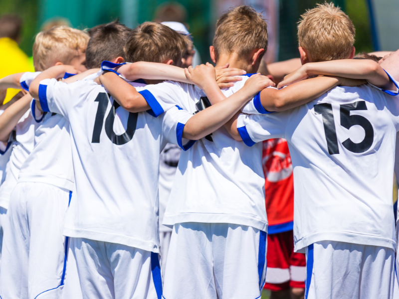 Enfants qui se réunissent durant leur match de foot en colonie de vacances ce printemps