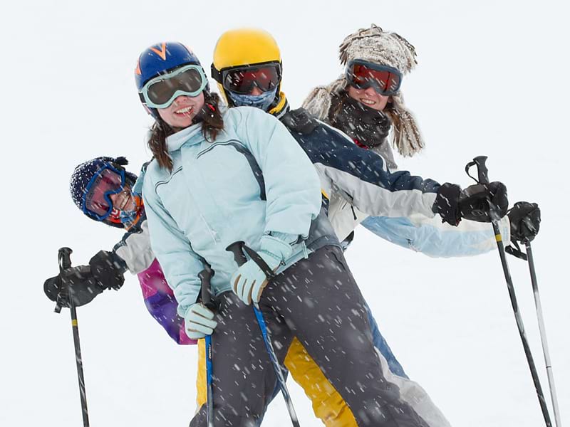 Groupe d'ados qui profitent de leur colo de vacances et s'amusent en skiant