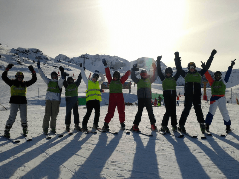 Groupe de jeunes en colo de vacances qui apprennent à skier