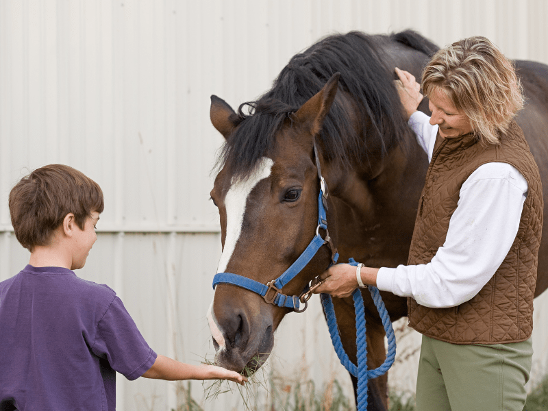 Enfant avec sa monitrice d'équitation en colonie de vacances Poneys