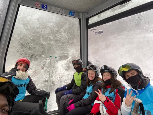 Groupe d'enfants heureux sur les pistes de ski en colonie de vacances 
