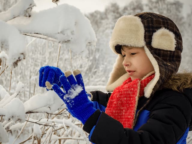 Jeune garçon qui s'amuse dans la neige durant sa colo au ski
