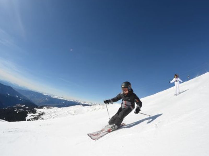 Descente d'une piste de ski par un jeune lors d'une colo ski et snow dans les Dolomites