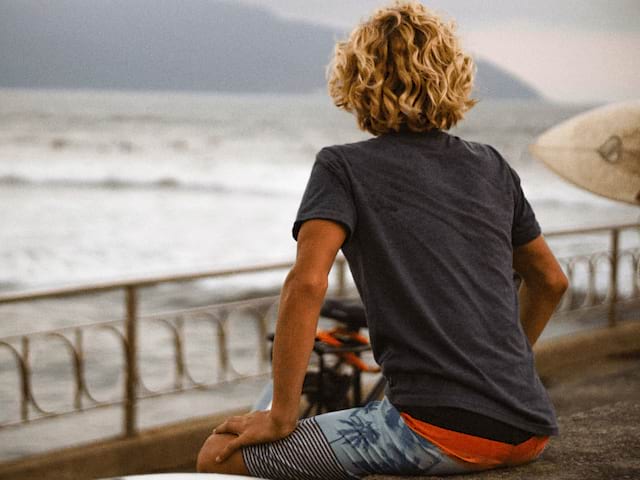 Jeune garçon en colo de vacances sur la Cote d'Azur qui observe la mer