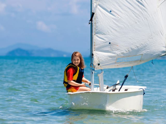 Jeune fille qui fait de l'optimist en colo de vacances ce printemps