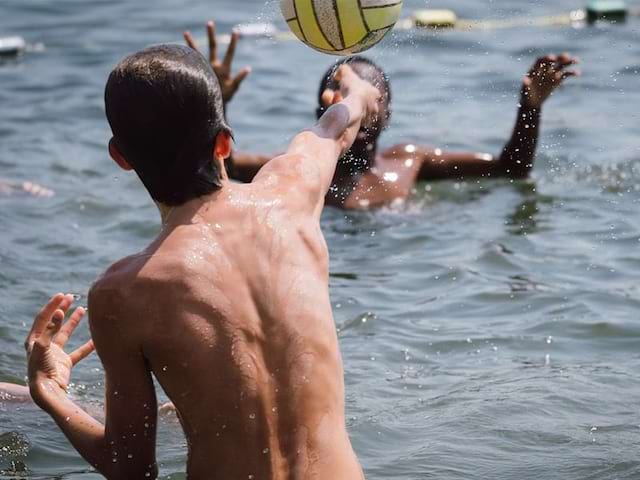 Jeunes qui s'amusent avec un ballon lors de leur colo à la mer durant l'été