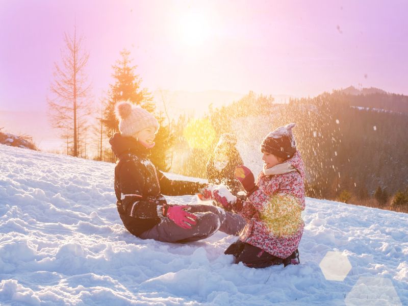 Jeunes filles en colo de vacances qui s'amusent dans la neige en février