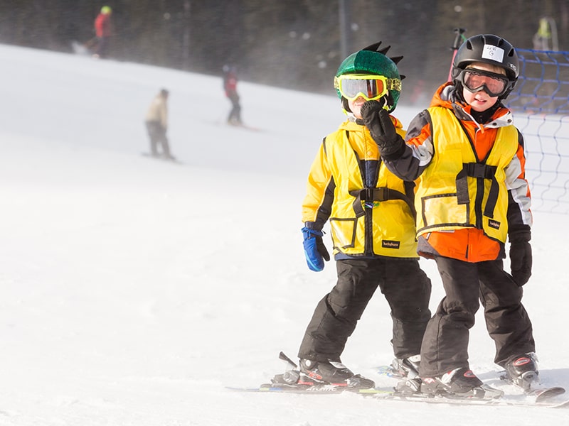 Deux enfants qui pratiquent le ski lors d'une colonie de vacances JO d'hiver