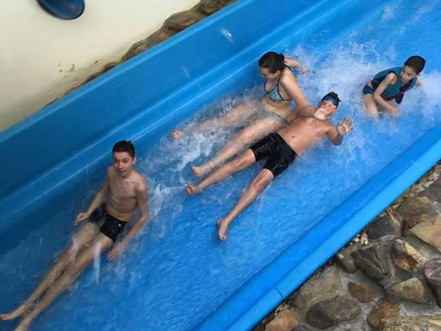 Enfants en colonie qui glissent dans un toboggan aquatique