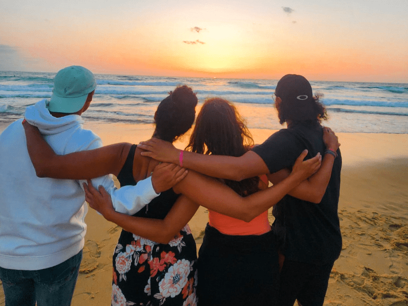 Groupe d'ados qui sont amis en colo de vacances et qui admirent le coucher de soleil