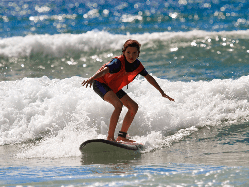 Jeune fille qui progresse en surf durant ses vacances d'automne