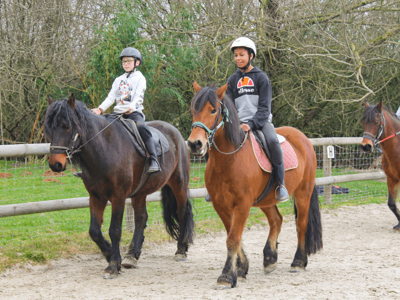 Deux jeunes en colo de vacances 100 % Equitation qui montent à cheval