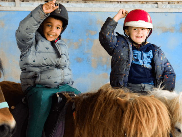 Deux jeunes copains en colo de vacances Equitation qui s'amusent en colo