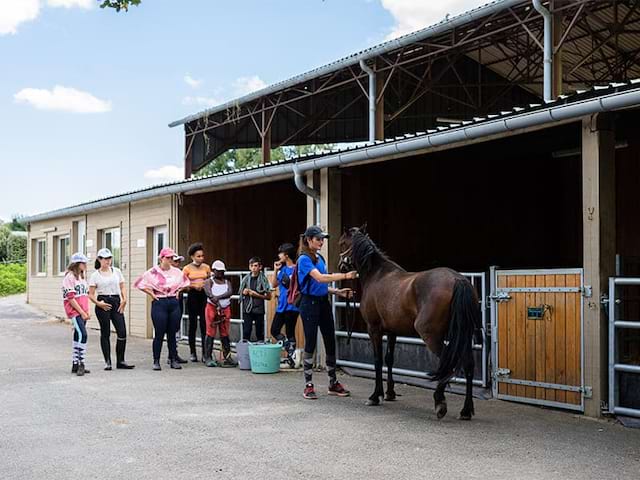 Vue sur les box de chevaux en colo de vacances au domaine de l'Espérance