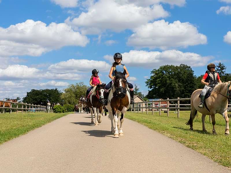 Jeunes cavaliers sur leur cheval lors d'une colo de vacances équestre au domaine de l'Esperance