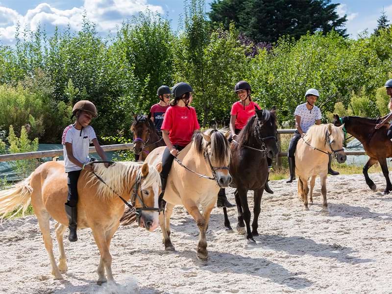 Enfants sur leur monture lors d'une colo de vacances équestre au printemps