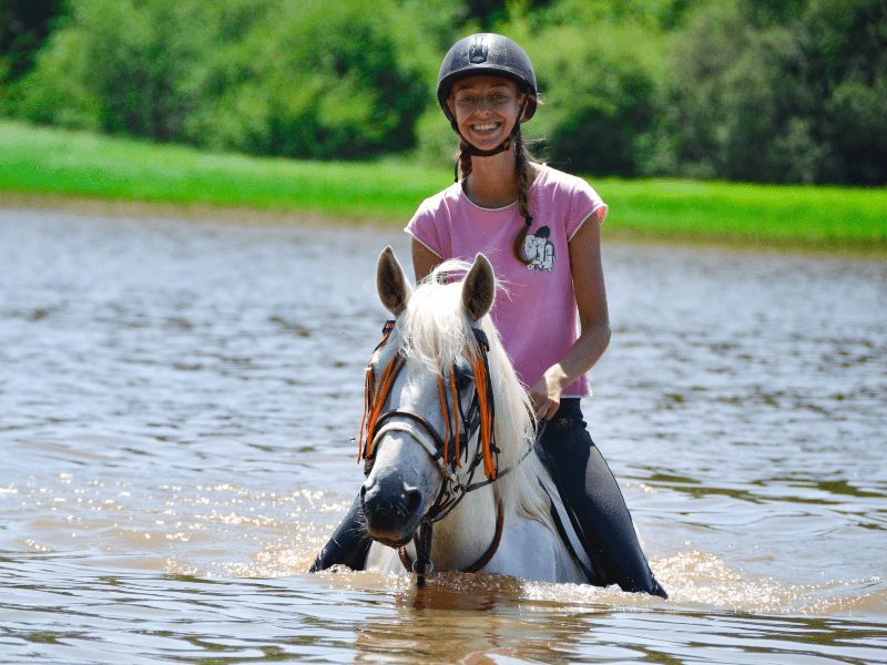 Jeune ado en colonie de vacances qui fait du cheval cet été