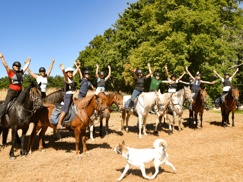 Groupe de jeunes ados en colo de vacances, heureux de faire de l'équitation durant le séjour Equit'adventure cet été 