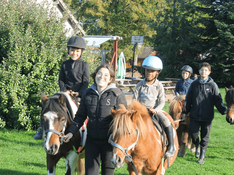 Enfants avec leur animatrice en colo de vacances Equitation cet automne