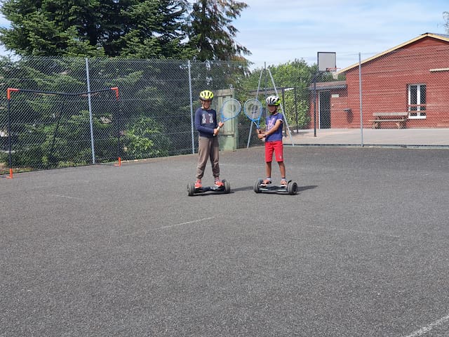 Enfants apprenant à faire de l'hoverboard cet été en colonie de vacances