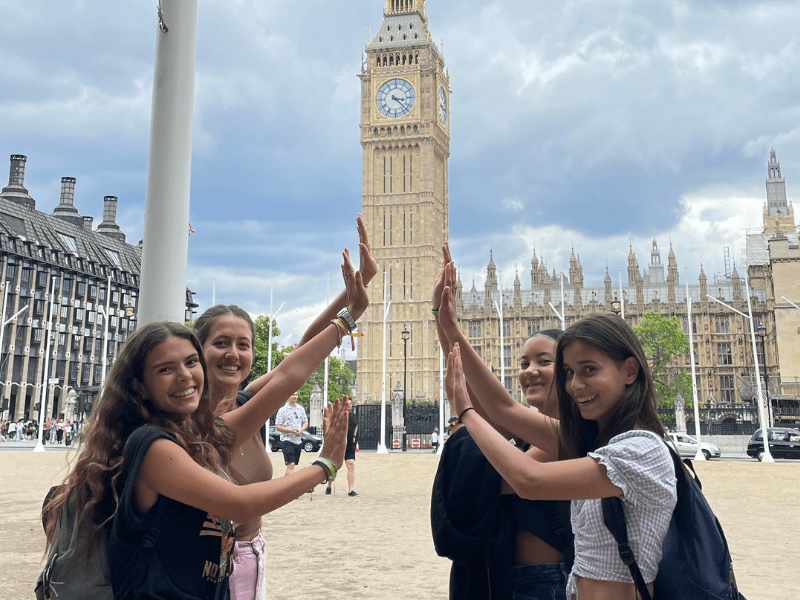 Filles qui s'amusent à prendre la pose devant Big Ben à Londres en colonie de vacances cet hiver