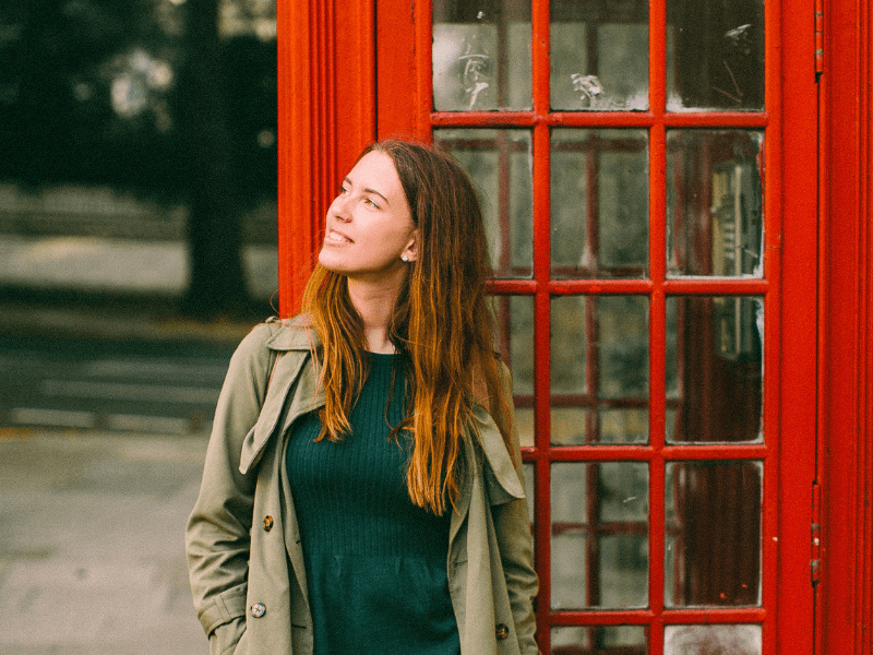 Jeune ado qui pose devant une cabine téléphonique à Londres durant sa colo de vacances