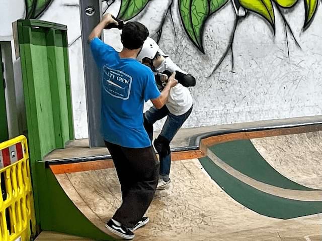 Enfant et son moniteur qui apprennent de nouvelles techniques de skate